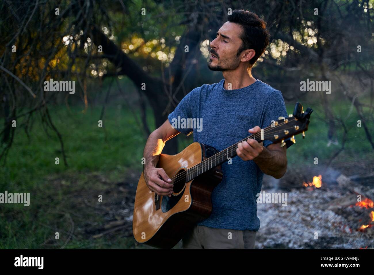 ritratto di giovane musicista che suona la chitarra al tramonto Foto Stock