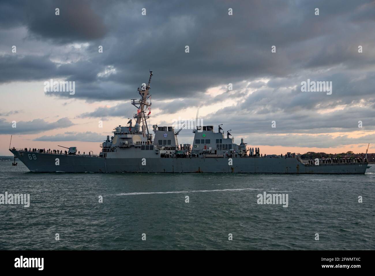 Il cacciatorpediniere della marina statunitense USS i Sullivans (DDG 68) che salpano da Portsmouth, Regno Unito al tramonto il 22 maggio 2021 come parte del gruppo britannico Carrier Strike. Foto Stock