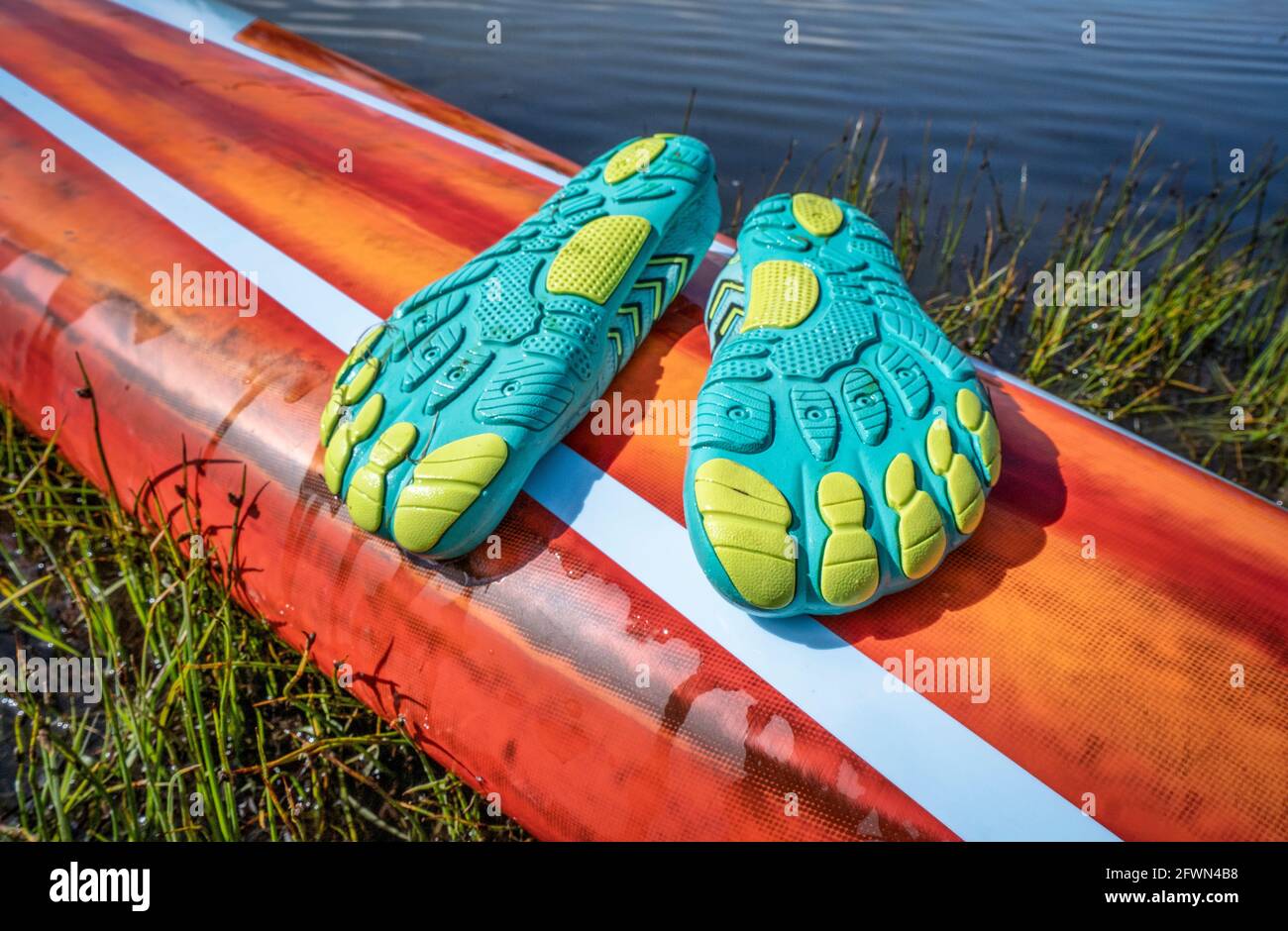 scarpe impermeabili leggere a basso profilo (suole in alto) per kayak e altri sport acquatici su un ponte di una pediera in piedi Foto Stock