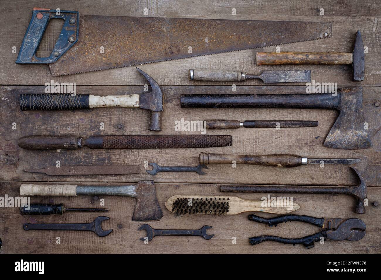 Collezione di antichi utensili a mano per la lavorazione del legno su un banco di lavoro grezzo vecchio legno Foto Stock