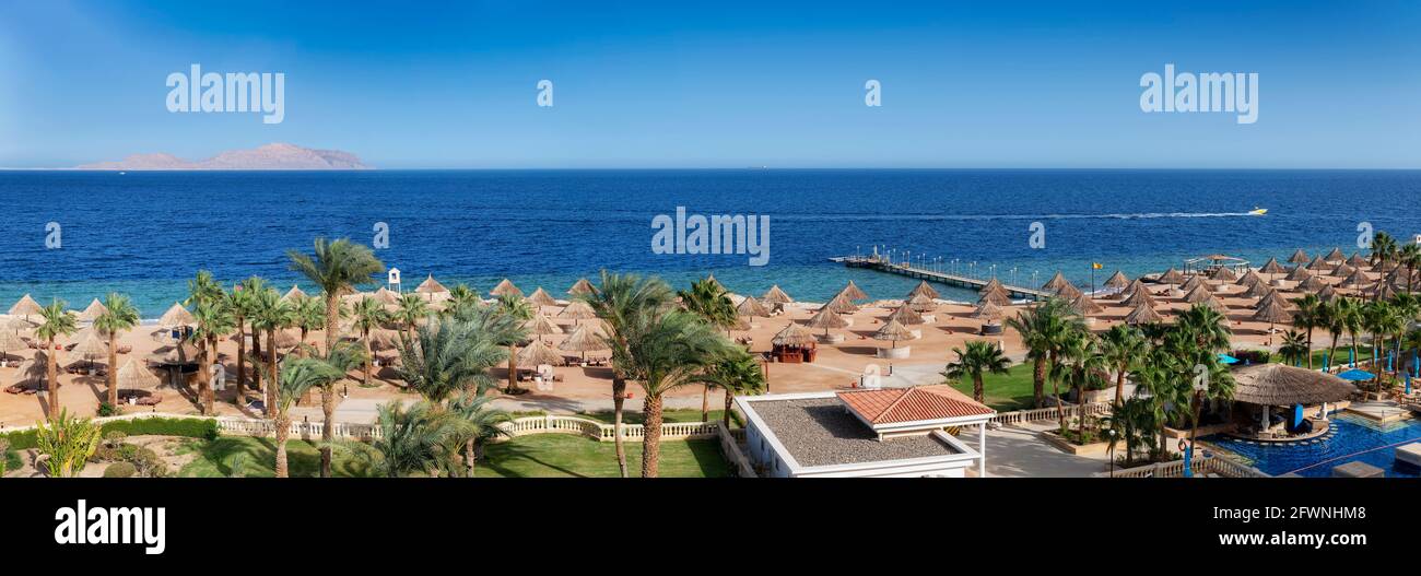 Spiaggia soleggiata in località tropicale, mare, palme, ombrelloni, vista panoramica aerea Foto Stock