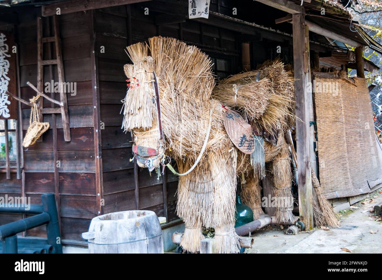 Un cavallo di paglia in un edificio di legno in Tsumago uno della vecchia città postale sul modo Nakasendo, Kiso Valley, Prefettura di Nagano, Giappone. Foto Stock