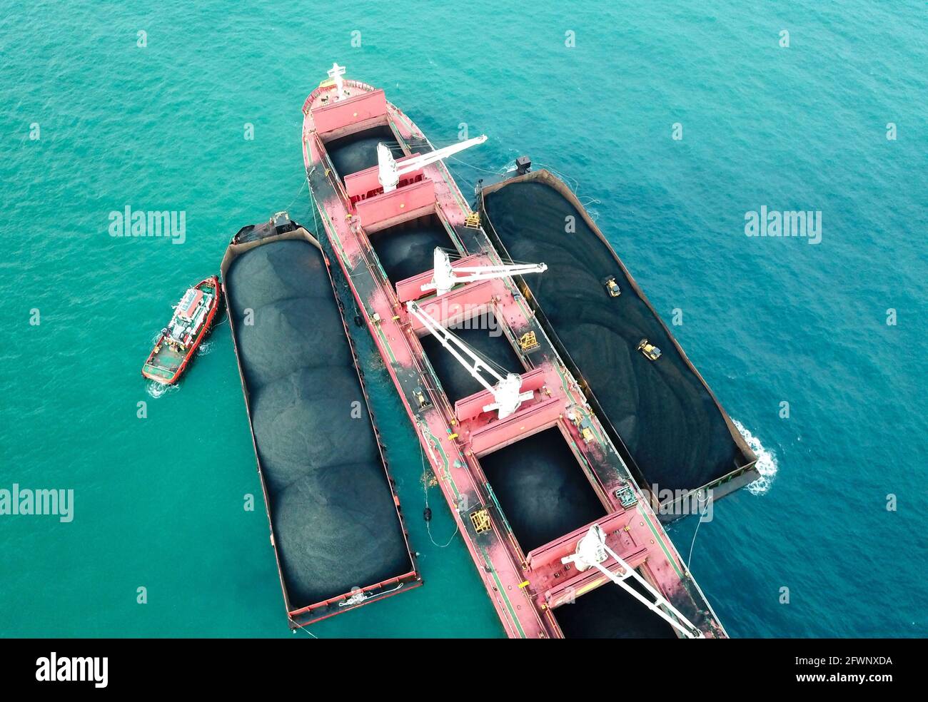 Trasporto del carbone dalla chiatta alla vista aerea della nave madre Foto Stock