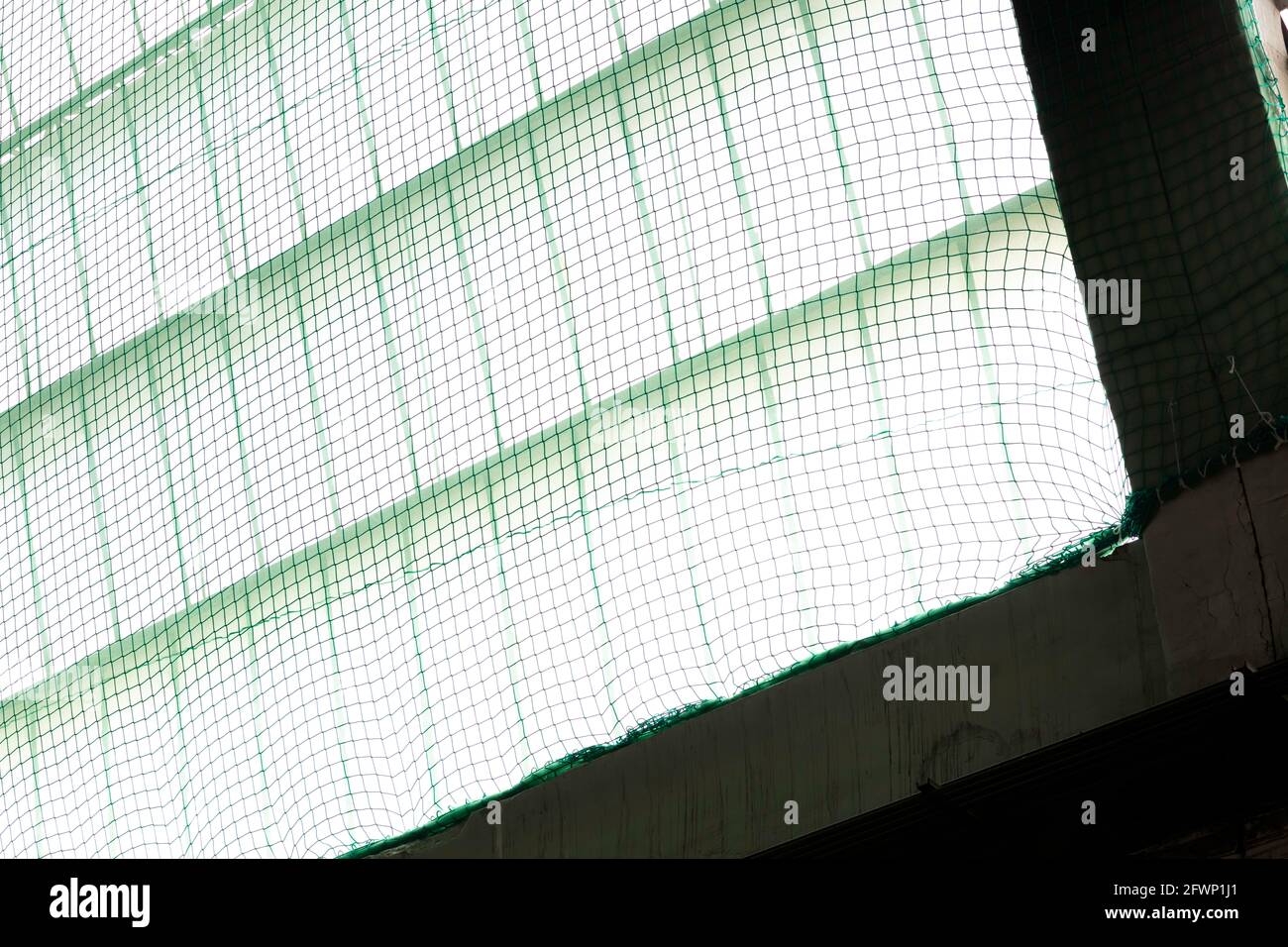 una rete di sicurezza di colore verde, posta sotto le finestre verticali per evitare il rischio di cadute durante i lavori Foto Stock