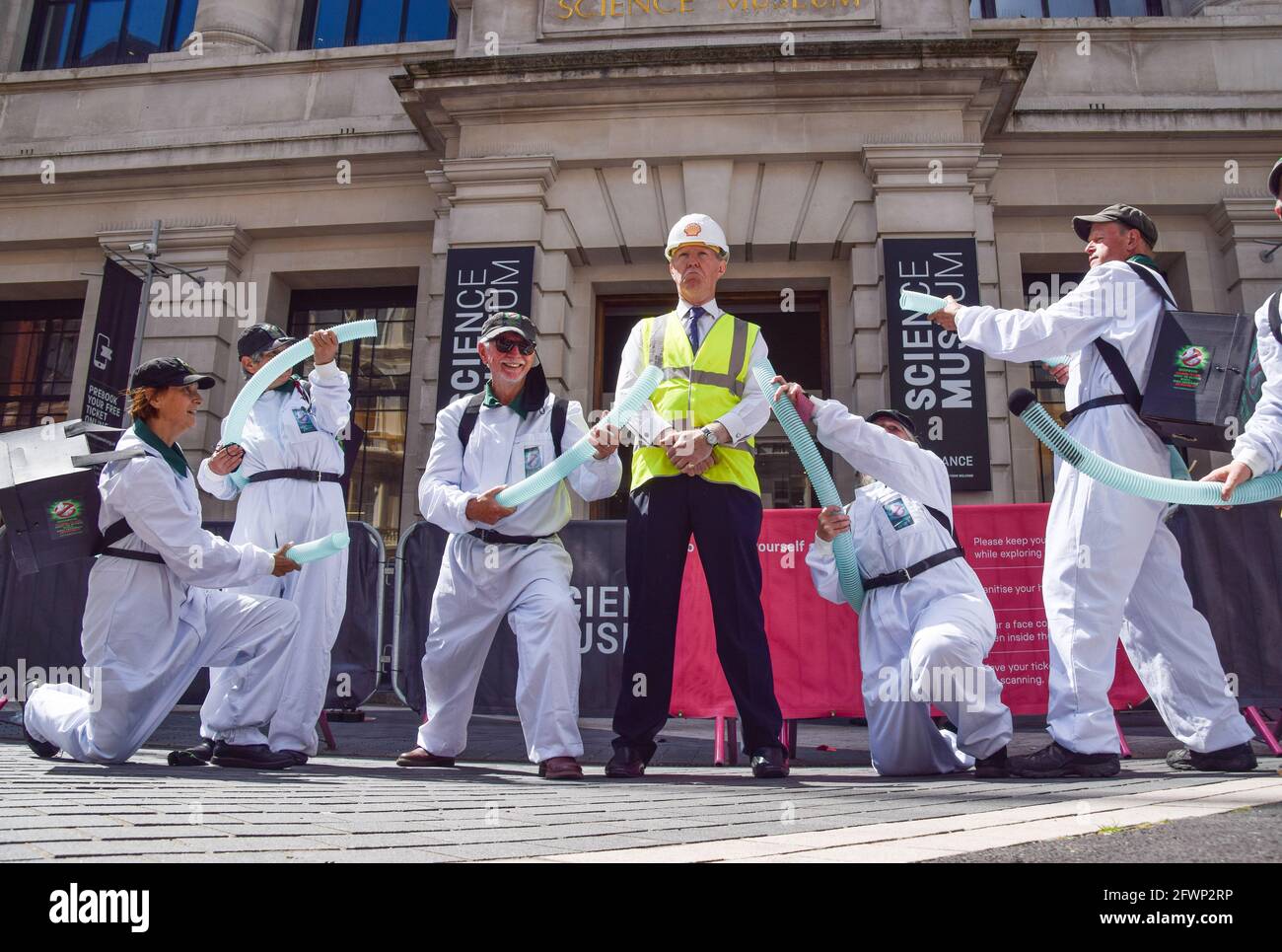 Londra, Regno Unito. 19 maggio 2021. Un protetore della ribellione dell'estinzione vestita come dirigente della Shell e come "Greenwash Busters" fuori dal Museo della Scienza di South Kensington. Manifestanti e scienziati si sono riuniti sia all'interno che all'esterno del museo per dimostrare contro la sponsorizzazione del gigante petrolifero Shell della mostra Our Future Planet Climate Change. Foto Stock