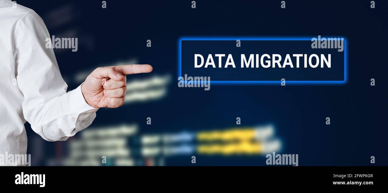 La mano maschile punta alla parola migrazione dei dati con background tecnologico. Foto Stock