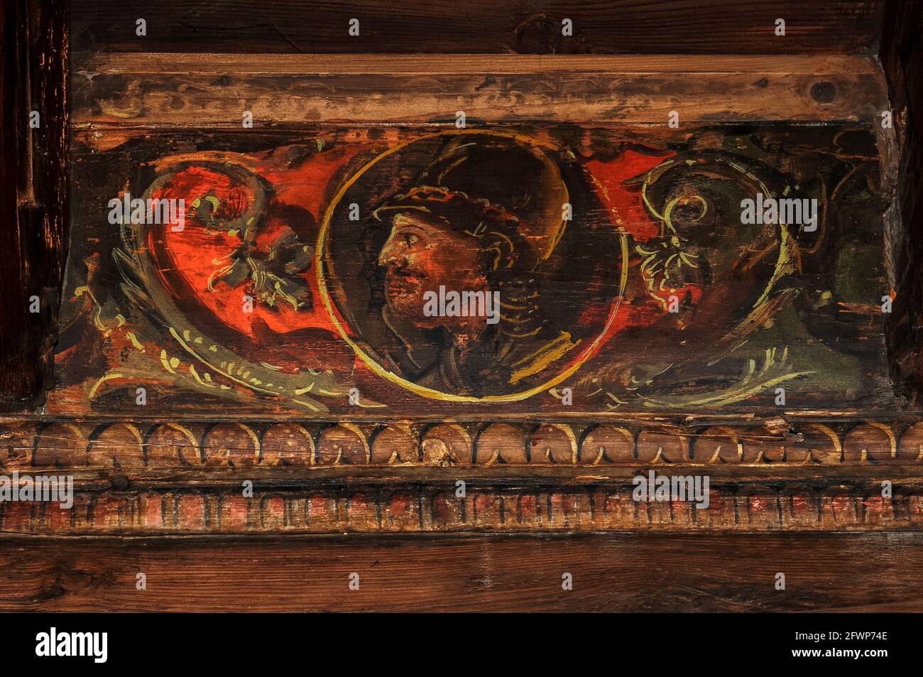 Soldato elmeto profilato in medaglione ritratto dipinto su soffitto in legno rinascimentale all'interno del Palazzo Magno o Palazzo Grande, ex residenza dei Principe-Vescovi di Trento a Trento, Trentino-Alto Adige, Italia. Il palazzo fu fondato nel 1528 nella fortezza del Buonconsiglio dal cardinale Bernardo Clesio o Clesio Cles, cancelliere del Sacro Romano Impero e principe-vescovo dal 1514 al 39. Il suo schema decorativo fonde soggetti mitologici con scene storiche e motivi imperiali come le armi e i ritratti degli imperatori asburgici. Foto Stock