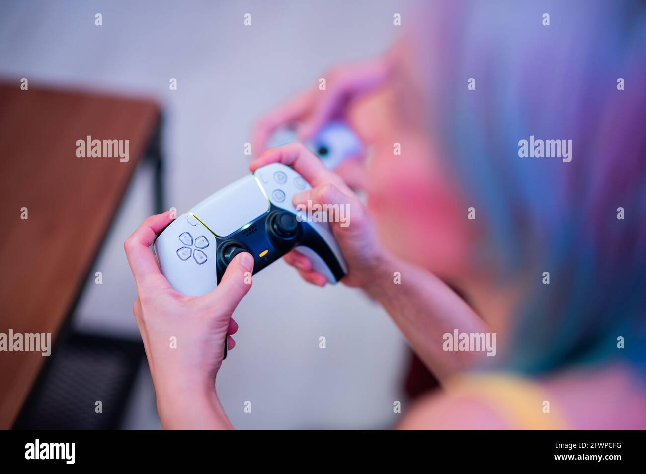 Ragazza con controller di prossima generazione nelle sue mani giocando a giochi a casa Foto Stock