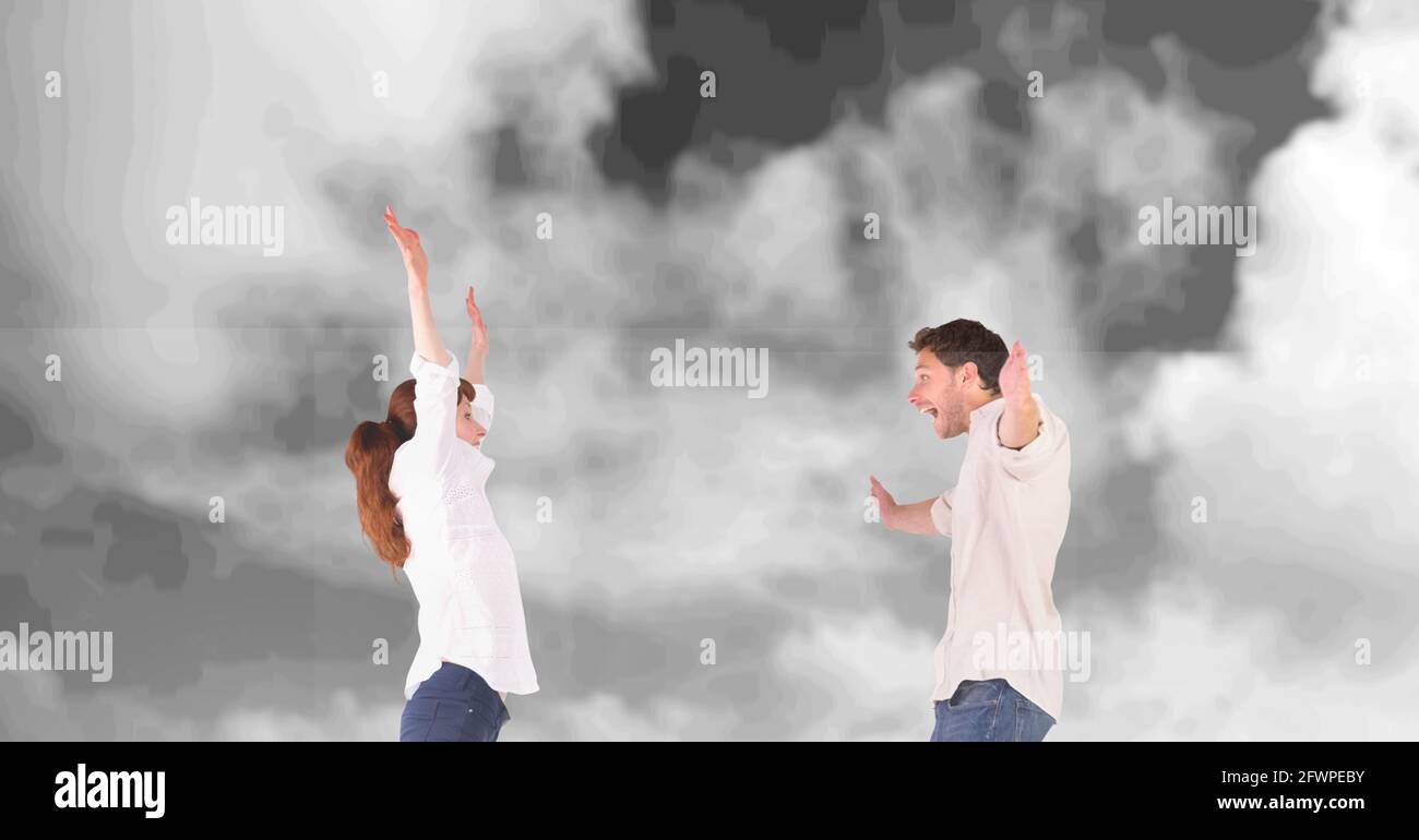 Composizione di felice coppia festeggiando con le braccia allungate su nero e cielo bianco nuvoloso Foto Stock