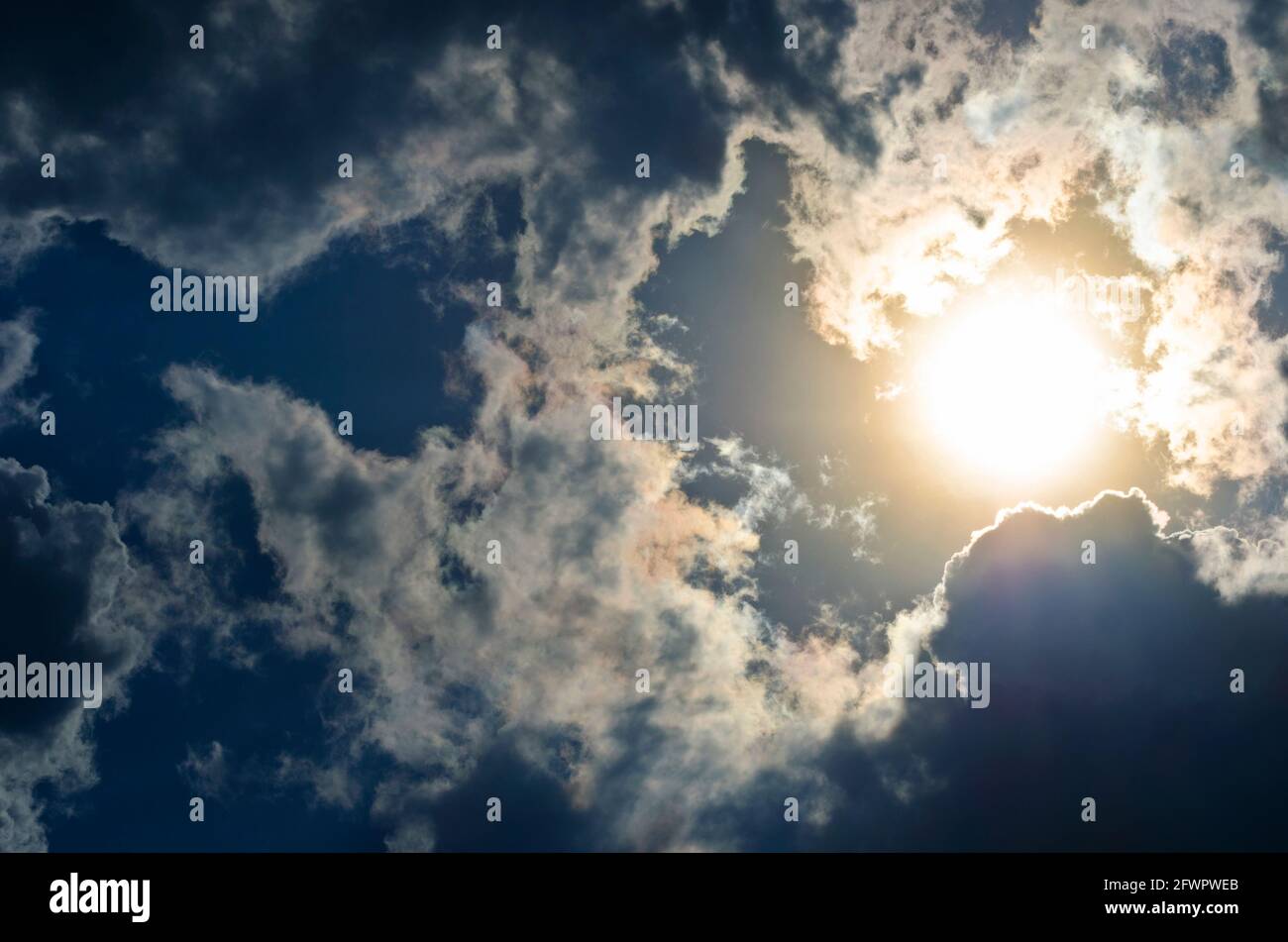 Cielo drammatico con sole luminoso e nuvole scure Foto Stock