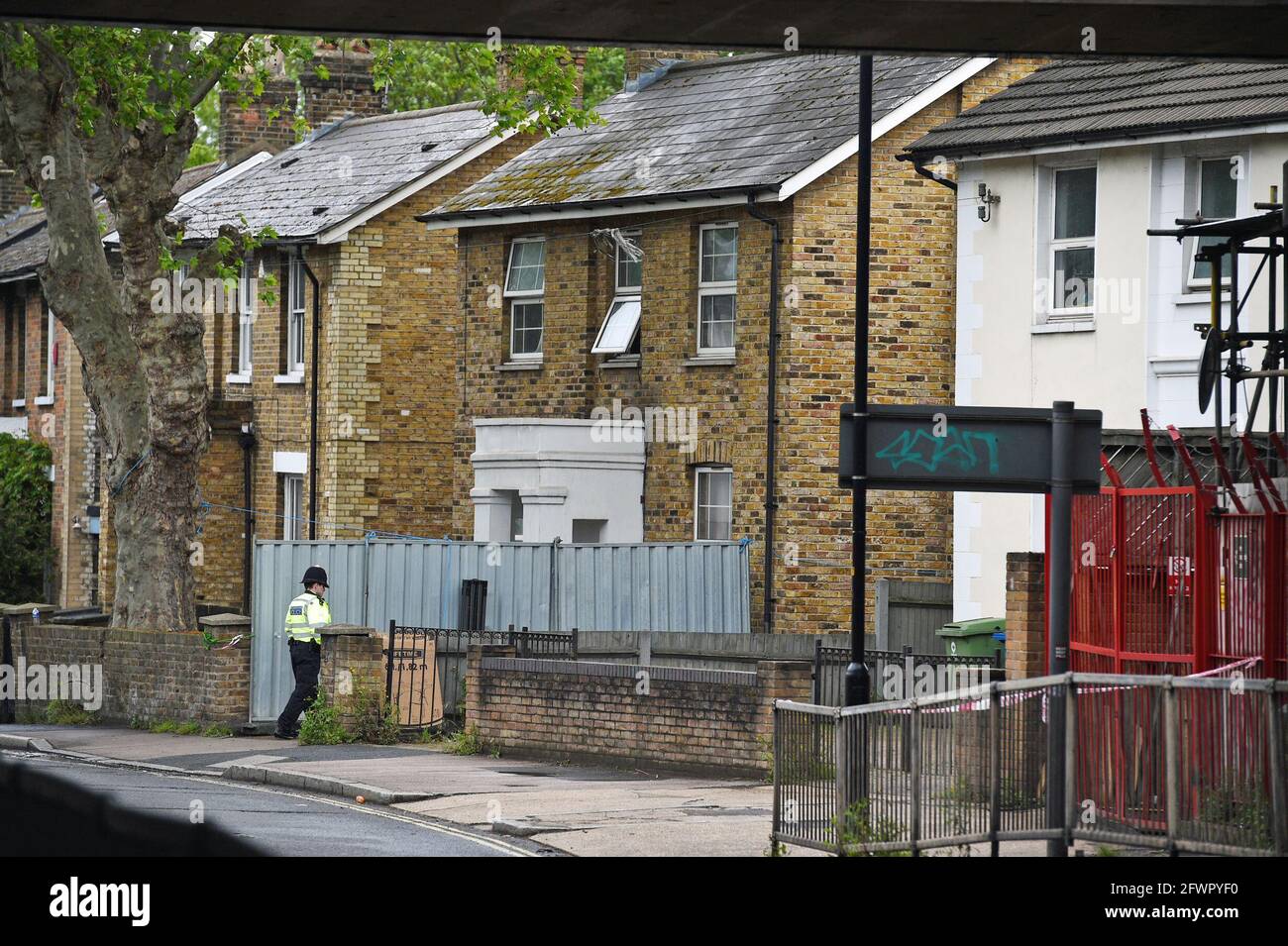 Un ufficiale di polizia protegge una casa a Consort Road, Peckham, a sud-est di Londra, dove l'attivista nero per la parità di diritti e la madre di tre Sasha Johnson sono stati fucilati in testa durante le prime ore di domenica. Data immagine: Lunedì 24 maggio 2021. Foto Stock