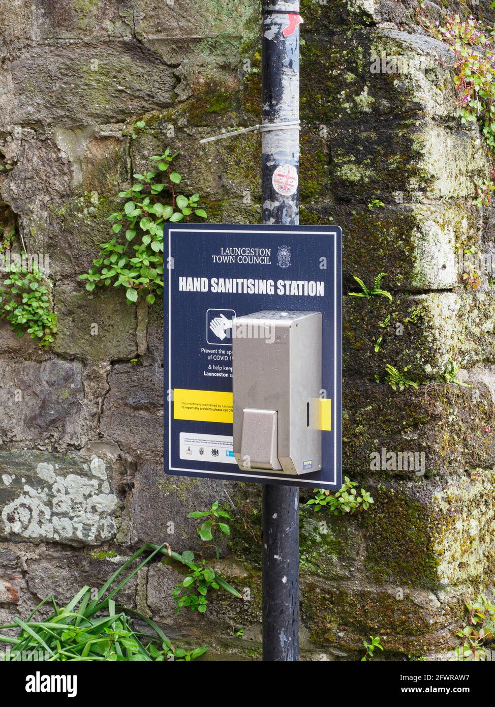 Stazione di igienizzazione a mano collegata al posto di segno mantenuto da Launceston Town council, Cornovaglia, Regno Unito Foto Stock