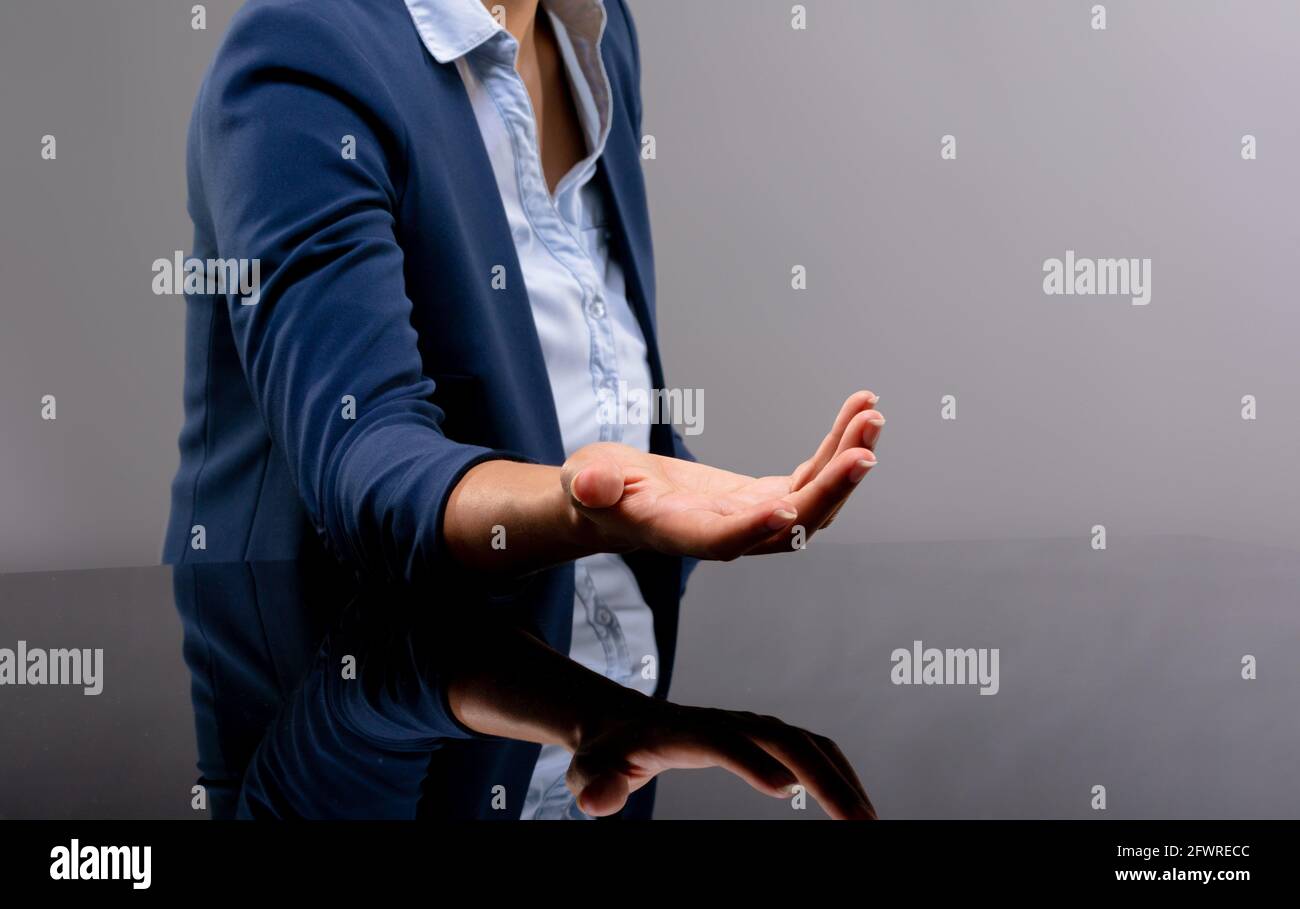 Sezione centrale di donna d'affari con la mano imbutita su sfondo grigio Foto Stock