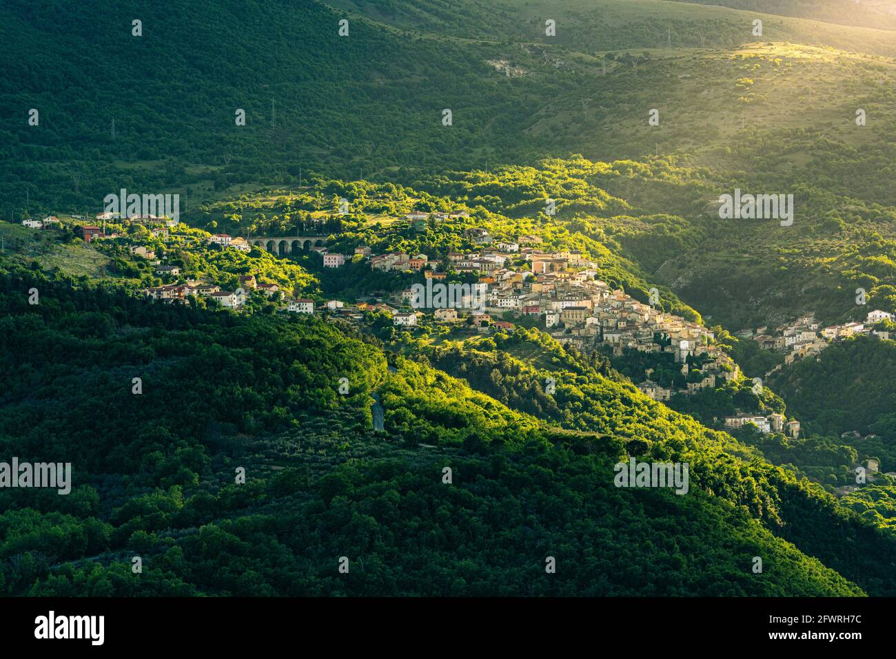 Vista dall'alto del piccolo borgo montano di Prezza illuminato da un raggio di sole che filtra attraverso le nuvole. Bellezza, Abruzzo Foto Stock
