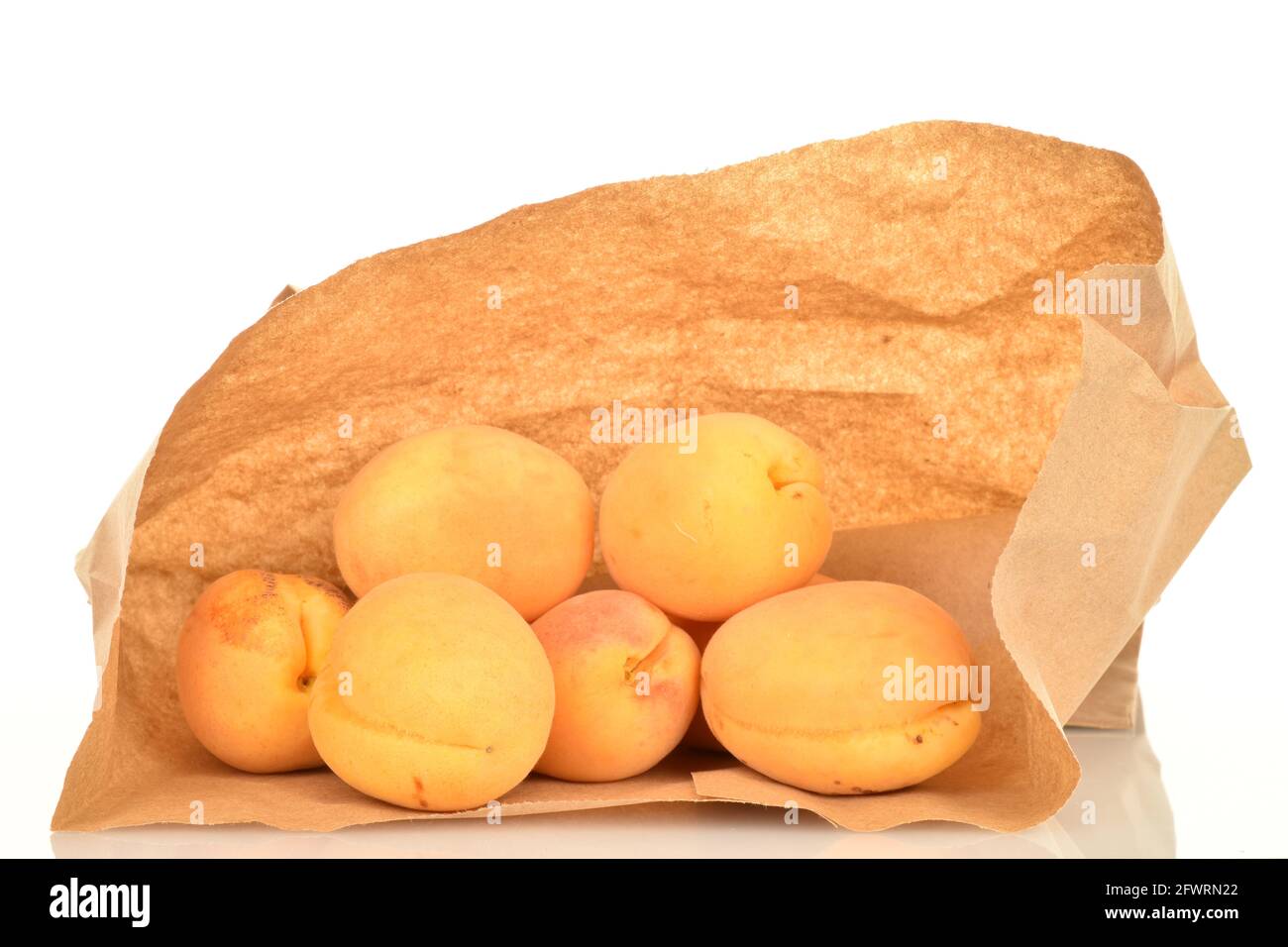 Diverse albicocche di ananas mature in un sacchetto di carta, primo piano, isolate su bianco. Foto Stock