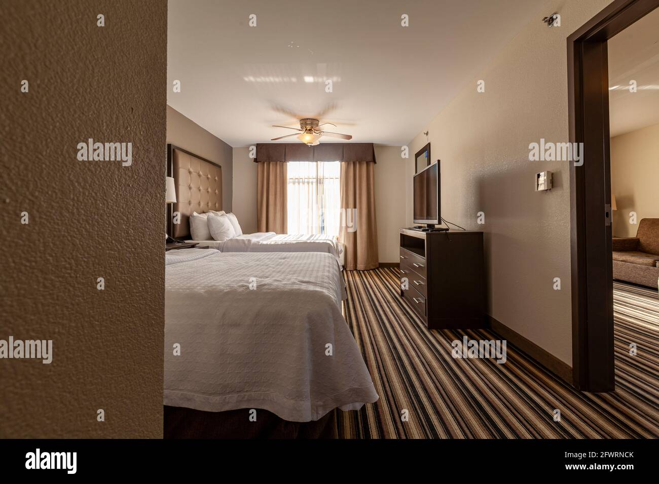 Columbus, OH, 05-19-2021: Una camera di hotel suite per famiglie con due letti queen size, pavimenti in moquette e un'area soggiorno separata. Televisore a schermo piatto Foto Stock