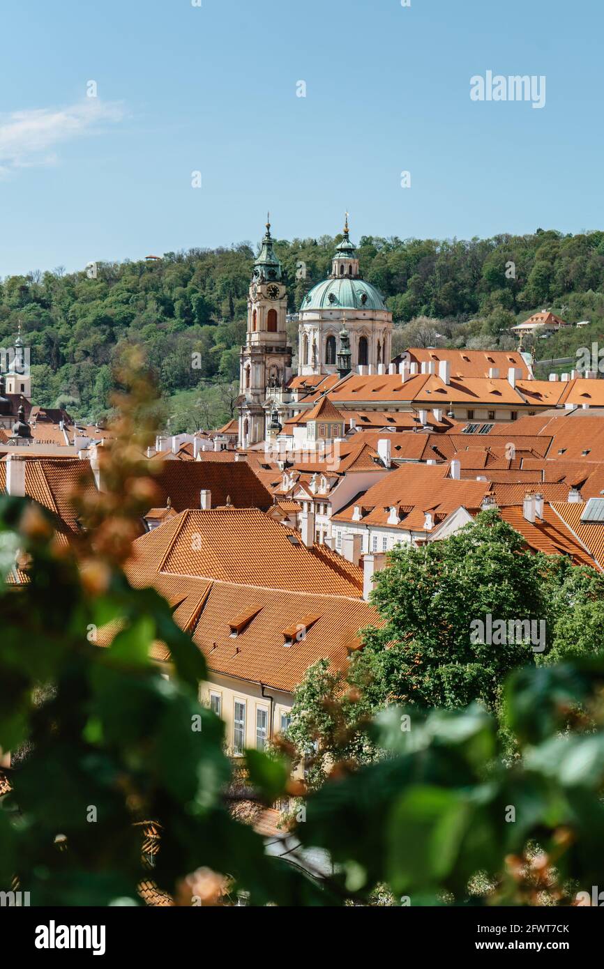Praga, Repubblica Ceca. Vista di primavera della Chiesa di San Nicola, città più piccola con edifici storici e tetti rossi. Sorprendente paesaggio urbano europeo. Foto Stock