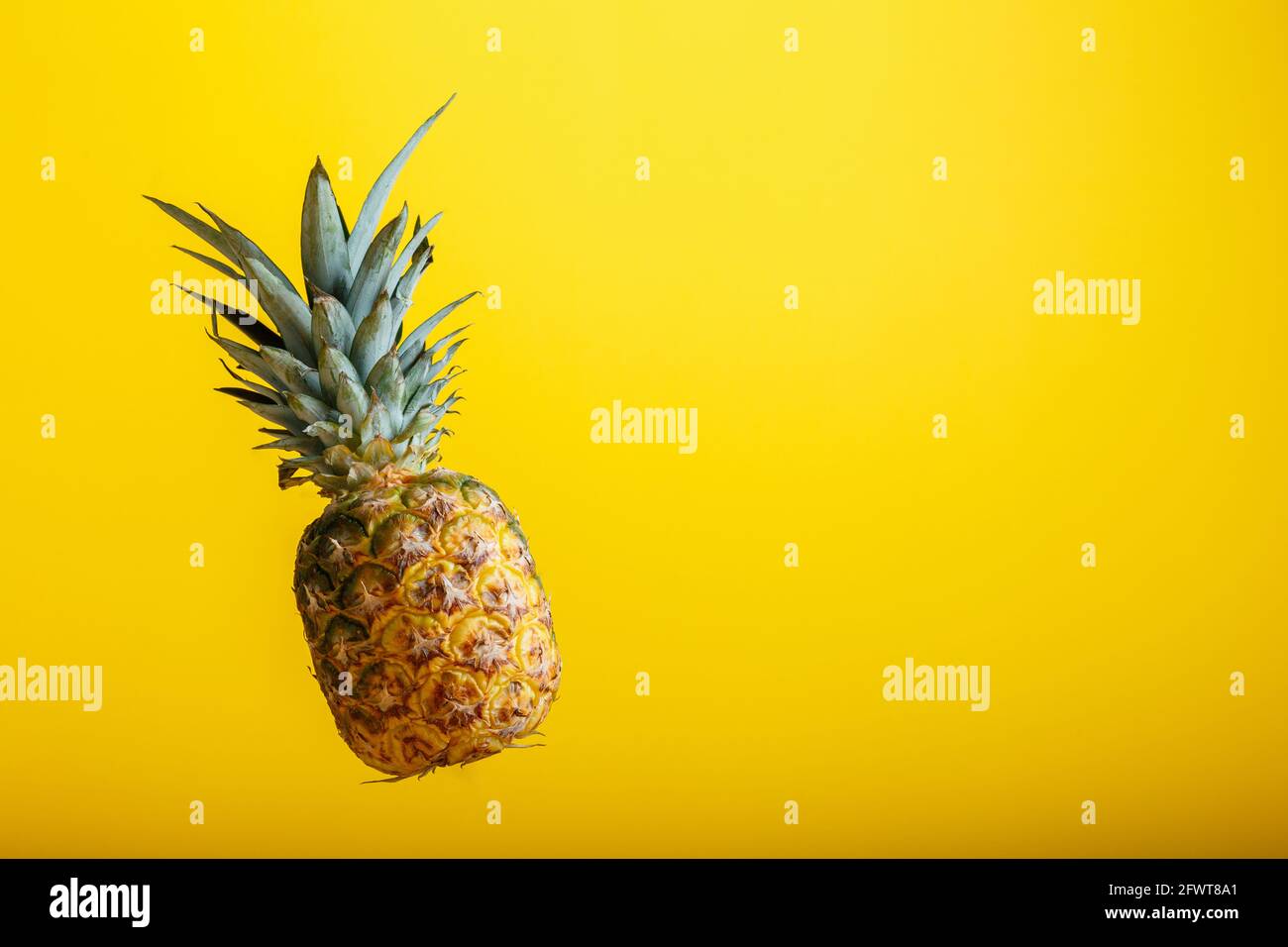 Levitazione di ananas su sfondo giallo di colore con spazio di copia. Intera frutta tropicale ananas minimalismo concetto vacanza estate background. Foto Stock