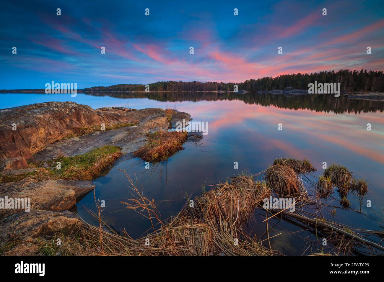 Cielo colorato e riflessi in una serata di primavera a Virebukt nel lago Vansjø, Østfold, Norvegia, Scandinavia. Foto Stock