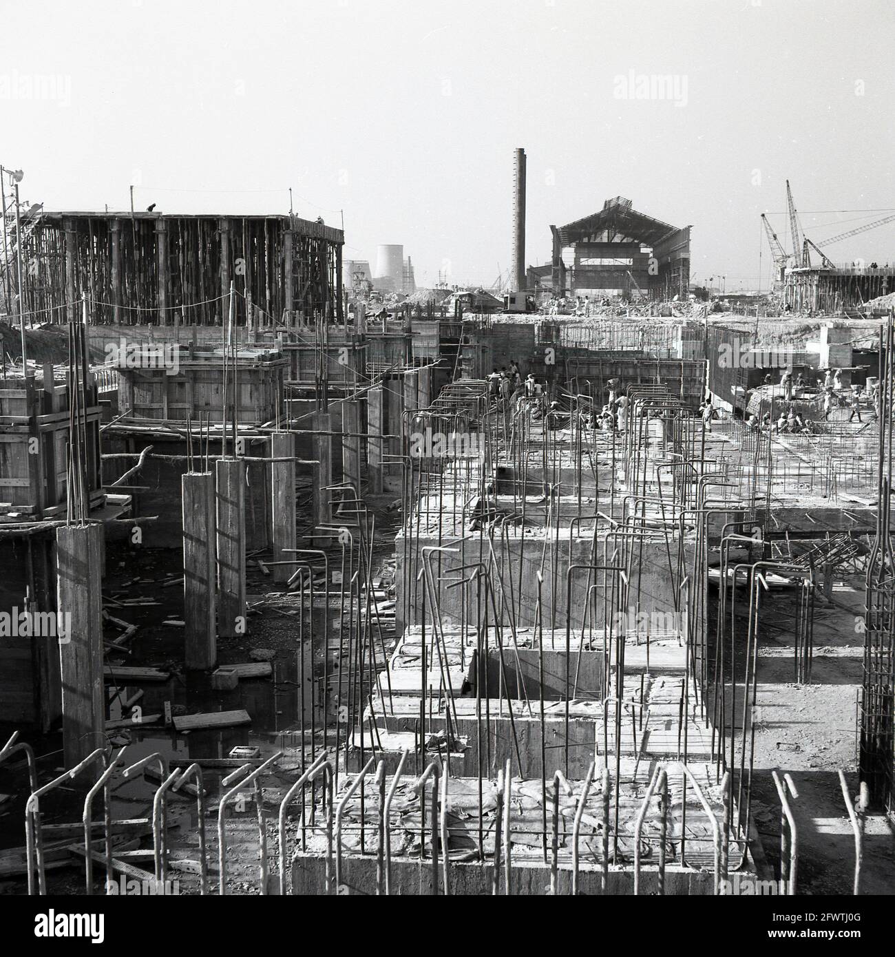 Alla fine degli anni '50, immagine storica della costruzione del gigante Durgapur Steel Plant, Durgapur, Bengala Occidentale, India, dopo l'indipendenza, Lo stabilimento siderurgico è stato uno dei primi grandi progetti di costruzione in India e nel 1957 una società indiana, Patel Engineering, in collaborazione con un'azienda britannica, Cementation UK, ha intrapreso l'intero progetto di ingegneria civile e di terra. Il massiccio complesso industrale ha coinvolto fondazioni di costruzione e macchinari, pali di cemento, strutture edili, binari ferroviari, strade e altri serivces come il drenaggio e un approvvigionamento idrico. Lo stabilimento è stato completato nel 1959. Foto Stock