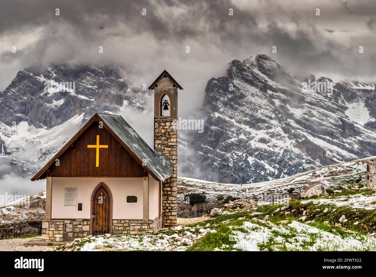 Cappella degli Alpini con cime dolomitiche sullo sfondo dopo una nevicata estiva, tre Cime di Lavaredo, Auronzo di Cadore, Italia Foto Stock