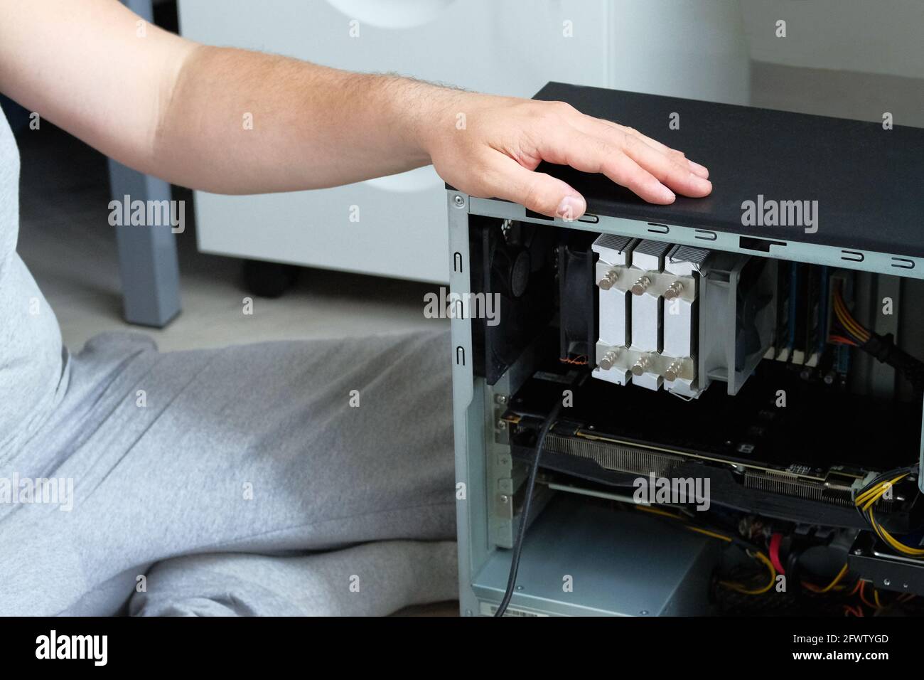 Un tecnico specializzato per la riparazione dei computer sta testando l'unità di sistema. Riparazione del calcolatore. Vista ravvicinata. Foto Stock