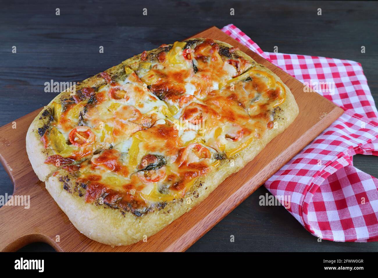 Appetitoso pesto vegetariano fresco cotto in casa pizza su un legno breadboard Foto Stock