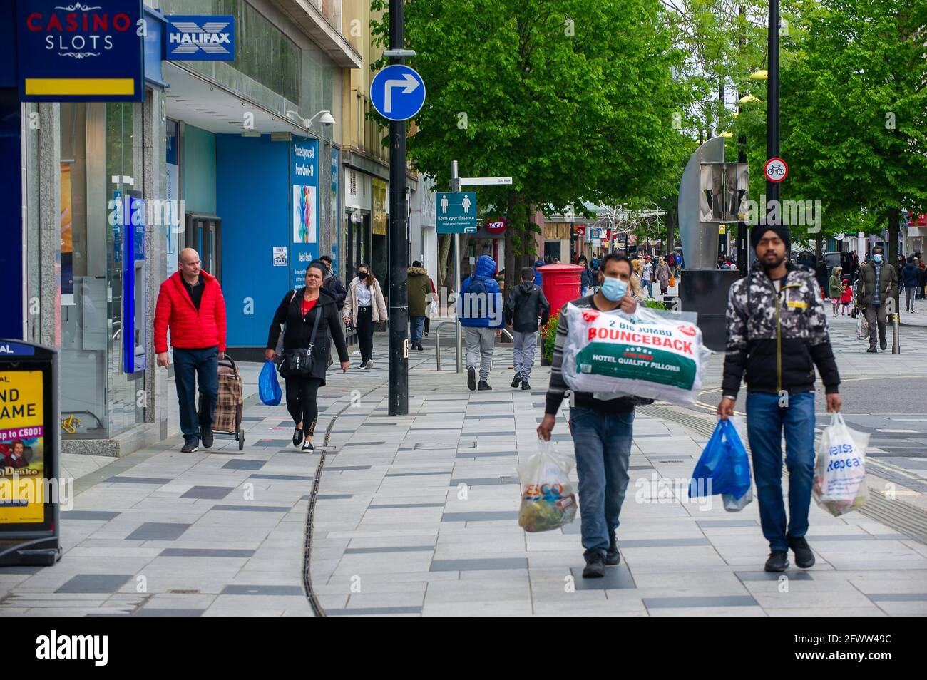 Slough, Berkshire, Regno Unito. 23 maggio 2021. Gli amanti dello shopping oggi a Slough High Street. Il tasso di infezione da rotolamento di sette giorni Covid-19 per 100,000 persone in Slough per la settimana che termina il 18 maggio è salito a 25.4, rispetto a 22.7. Dato che il numero di casi positivi di variante indiana di Covid-19 sta iniziando ad aumentare, la possibile eliminazione di tutte le restrizioni di blocco a giugno potrebbe ora essere in pericolo. Credito: Maureen McLean/Alamy Foto Stock