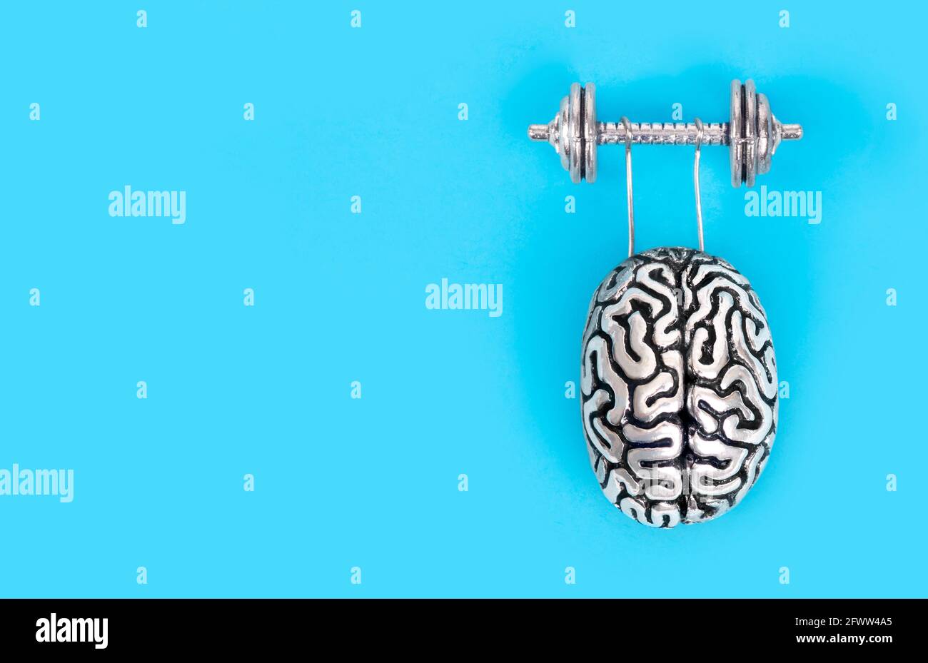 Composizione creativa fatta di una copia in acciaio del cervello umano che solleva un pesante manubri. Concetto di allenamento cerebrale. Foto Stock