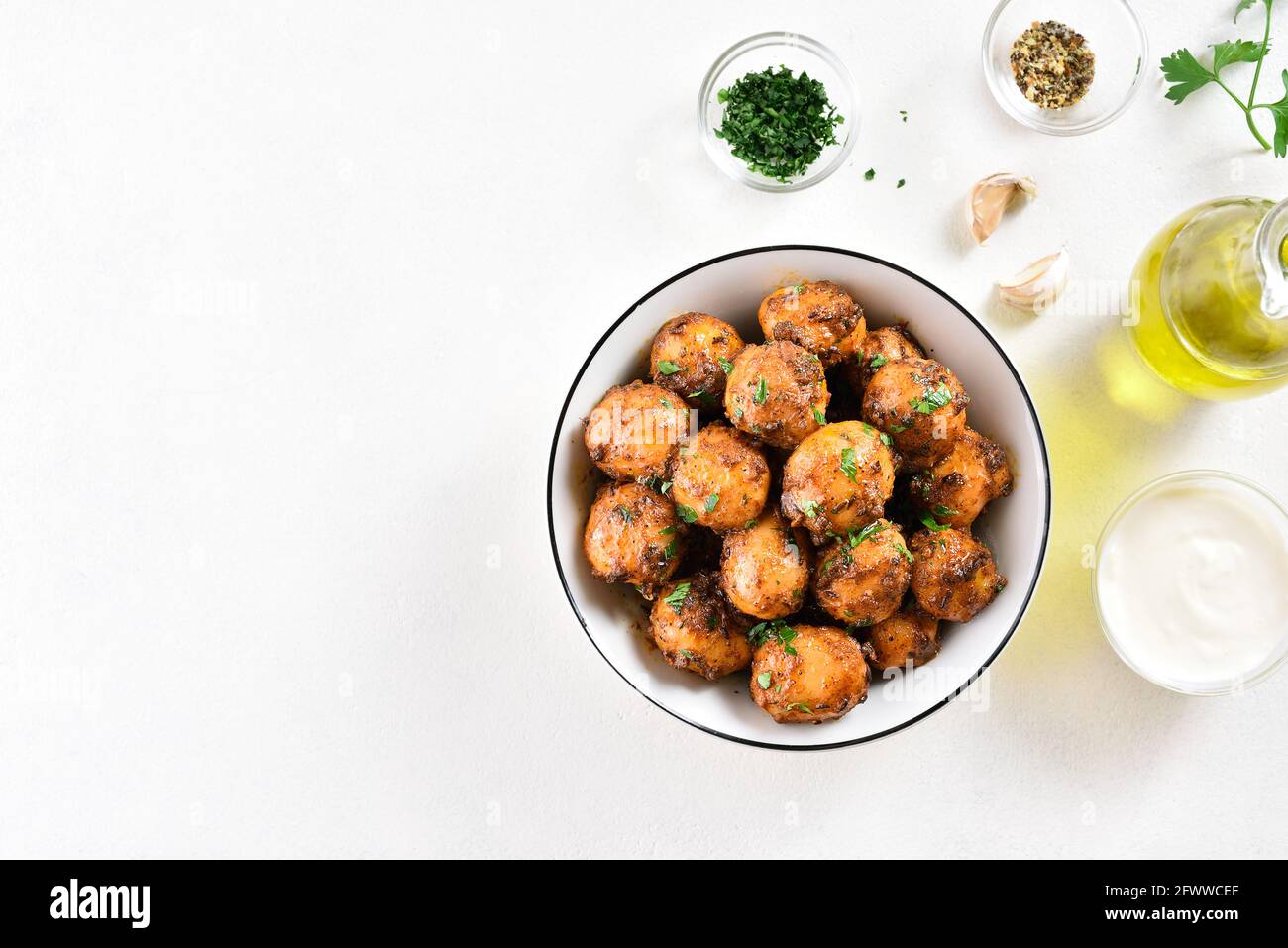 Patate Bombay. Pan patate fritte piccolo bambino con i semi di jeera e coriandolo in ciotola su sfondo chiaro con spazio libero di testo. Popolare piatto indiano. Foto Stock