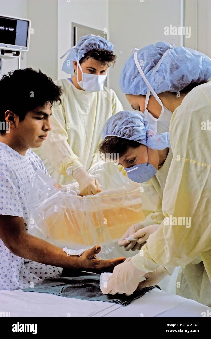 Masterizzare tre infermieri vestire un braccio del paziente e la mano. Foto Stock