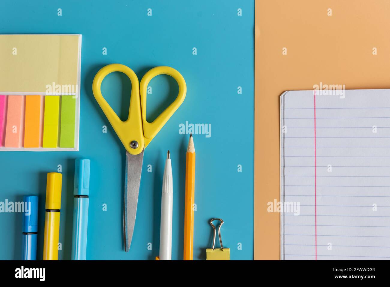 Articoli di cancelleria. Oggetti colorati per lo studio e il lavoro in ufficio su sfondo blu. Ritorno a scuola e lavoro dopo la quarantena. Foto Stock