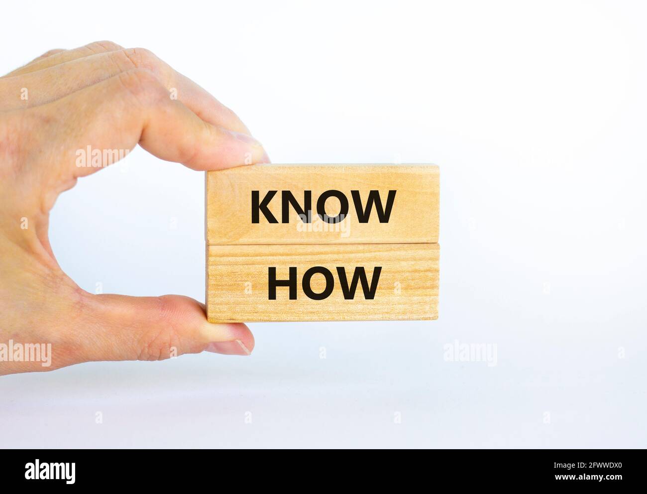 Conoscere il simbolo. Blocchi di legno con parole 'know how' su uno sfondo bianco bello, copia spazio. Mano uomo d'affari. Business, innovazione e know how co Foto Stock