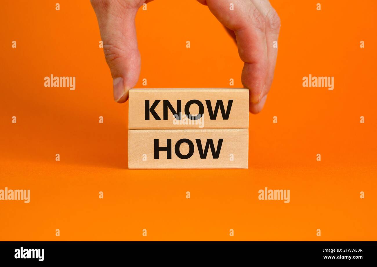 Conoscere il simbolo. Blocchi di legno con parole 'know how' su uno sfondo arancione bello, copia spazio. Mano uomo d'affari. Business, innovazione e know how c Foto Stock