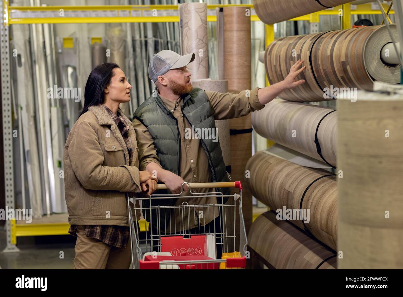 Uomo e donna che scelgono il linoleum per la loro casa o appartamento nel negozio di hardware Foto Stock