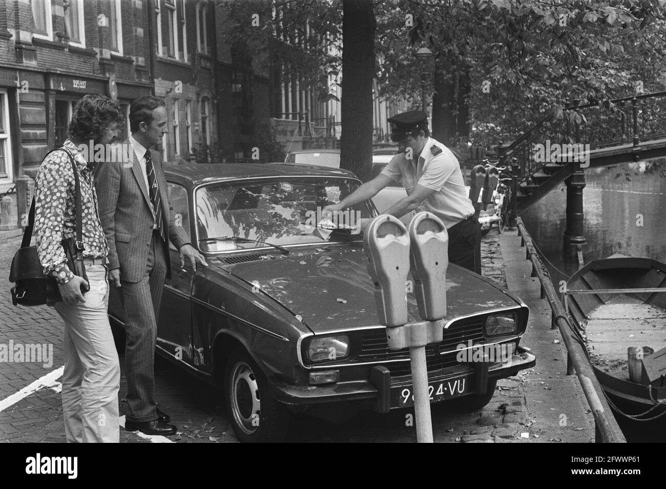 L'alderman Michael van der Vlis di Amsterdam (a sinistra) e Ir Jan Barkhof, vicedirettore esecutivo di ANWB, guarda come un addetto al parcheggio emette un biglietto con informazioni sui lotti P+R invece di una multa per un'auto parcheggiata erroneamente ad Amsterdam, 8 settembre 1981, automobili, direttori, condizioni di parcheggio, Parcheggi, addetti al parcheggio, aldermen, Paesi Bassi, foto agenzia stampa del XX secolo, notizie da ricordare, documentario, fotografia storica 1945-1990, storie visive, Storia umana del XX secolo, che cattura momenti nel tempo Foto Stock