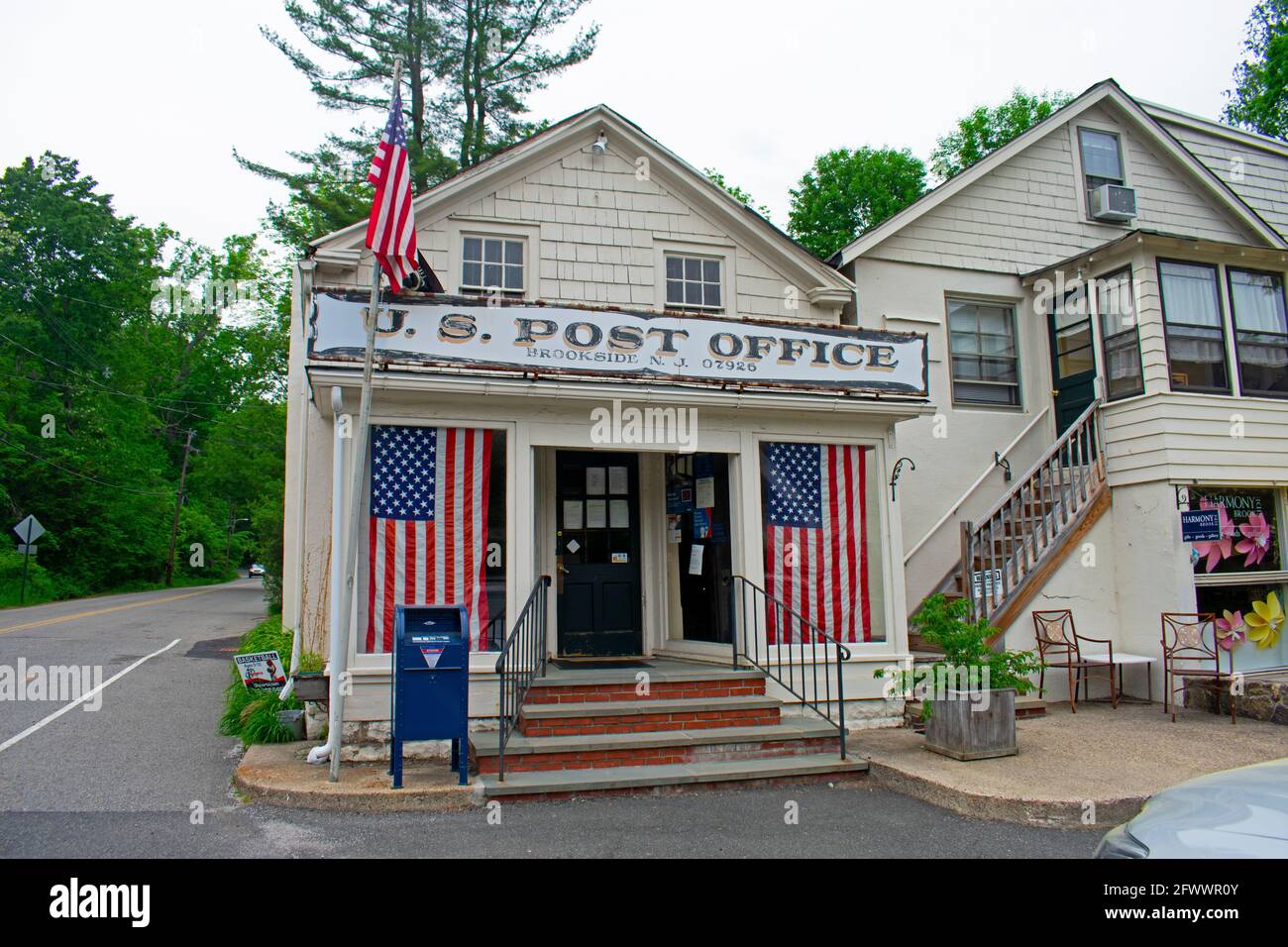 Carino, isolato, piccolo ufficio postale edificio a Mendham, NJ, con più bandiere statunitensi drappeggiato su di esso Foto Stock