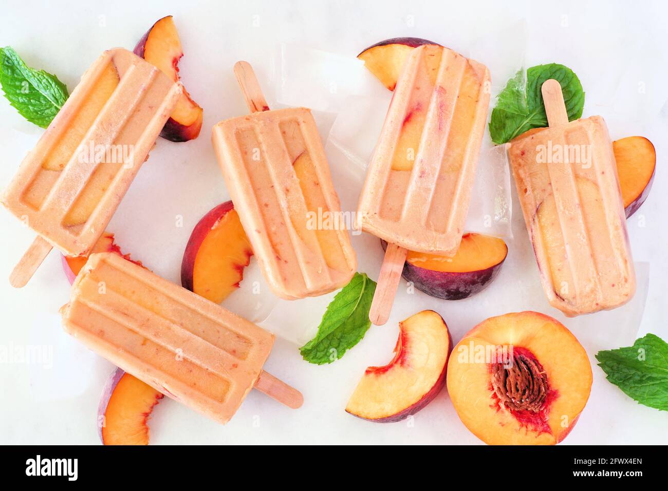 Summer Peach yogurt ghiaccio pops, vista dall'alto sparso su uno sfondo di marmo bianco Foto Stock
