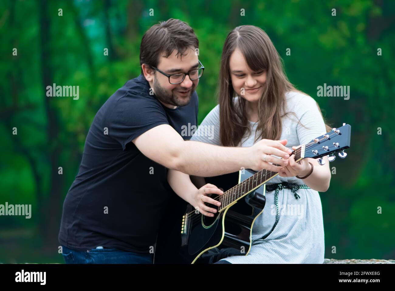 Fratello insegnava a suonare la chitarra in natura Foto Stock