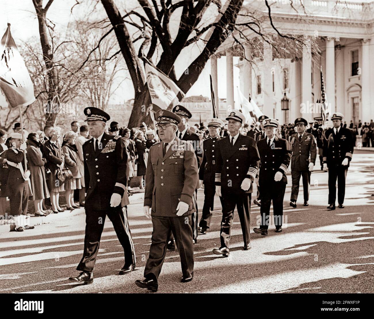 Funzionari militari camminano nella processione funeraria del presidente John F. Kennedy dalla Casa Bianca alla Cattedrale di San Matteo Apostolo. Funzionari: Presidente dei capi di Stato e di Stato maggiore, generale Maxwell D. Taylor; Capo di Stato maggiore dell'aviazione militare degli Stati Uniti, generale Curtis E. LeMay; Capo di Stato maggiore dell'esercito degli Stati Uniti, generale Earle G. Wheeler (parzialmente nascosto); Capo delle operazioni navali, ammiraglio David L. McDonald; Comandante del corpo marino degli Stati Uniti, il generale David M. Shoup; comandante della Guardia costiera degli Stati Uniti, l'ammiraglio Edwin J. Roland; l'Aide militare. Foto Stock