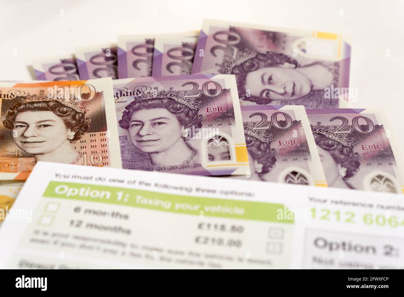 Pila di sterlina Banca d'Inghilterra note £20 su sfondo bianco con lettera di bolletta delle imposte stradali da pagare Foto Stock