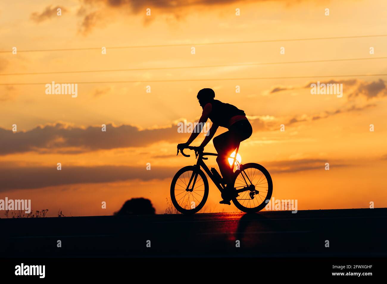 Silhouette di bicicletta attiva ciclista durante il tramonto Foto Stock