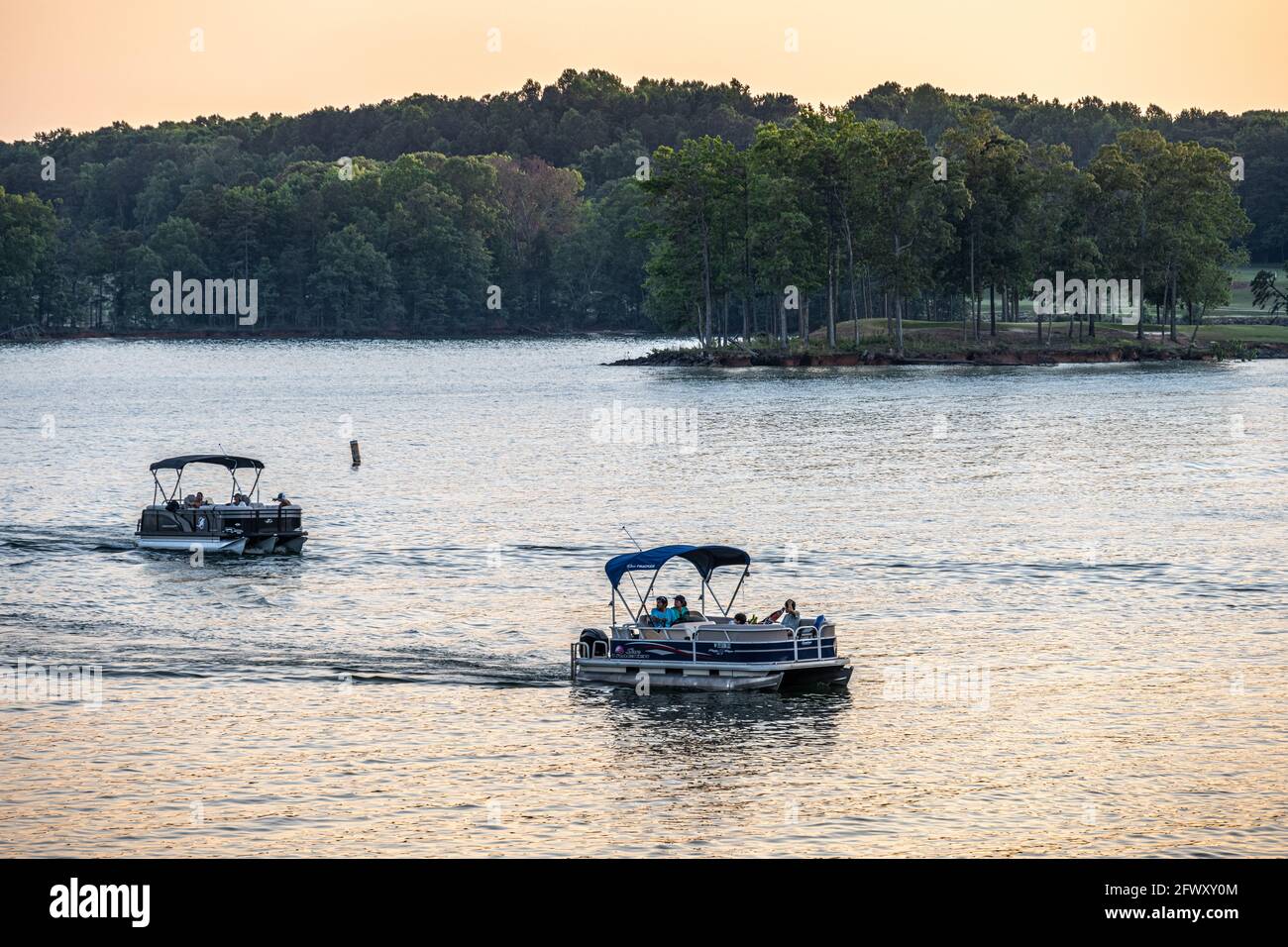 Le famiglie si rilassano sulle barche da pontile al tramonto sul lago Lanier lungo le rive del complesso turistico Lake Lanier Islands nella Georgia settentrionale. (STATI UNITI) Foto Stock