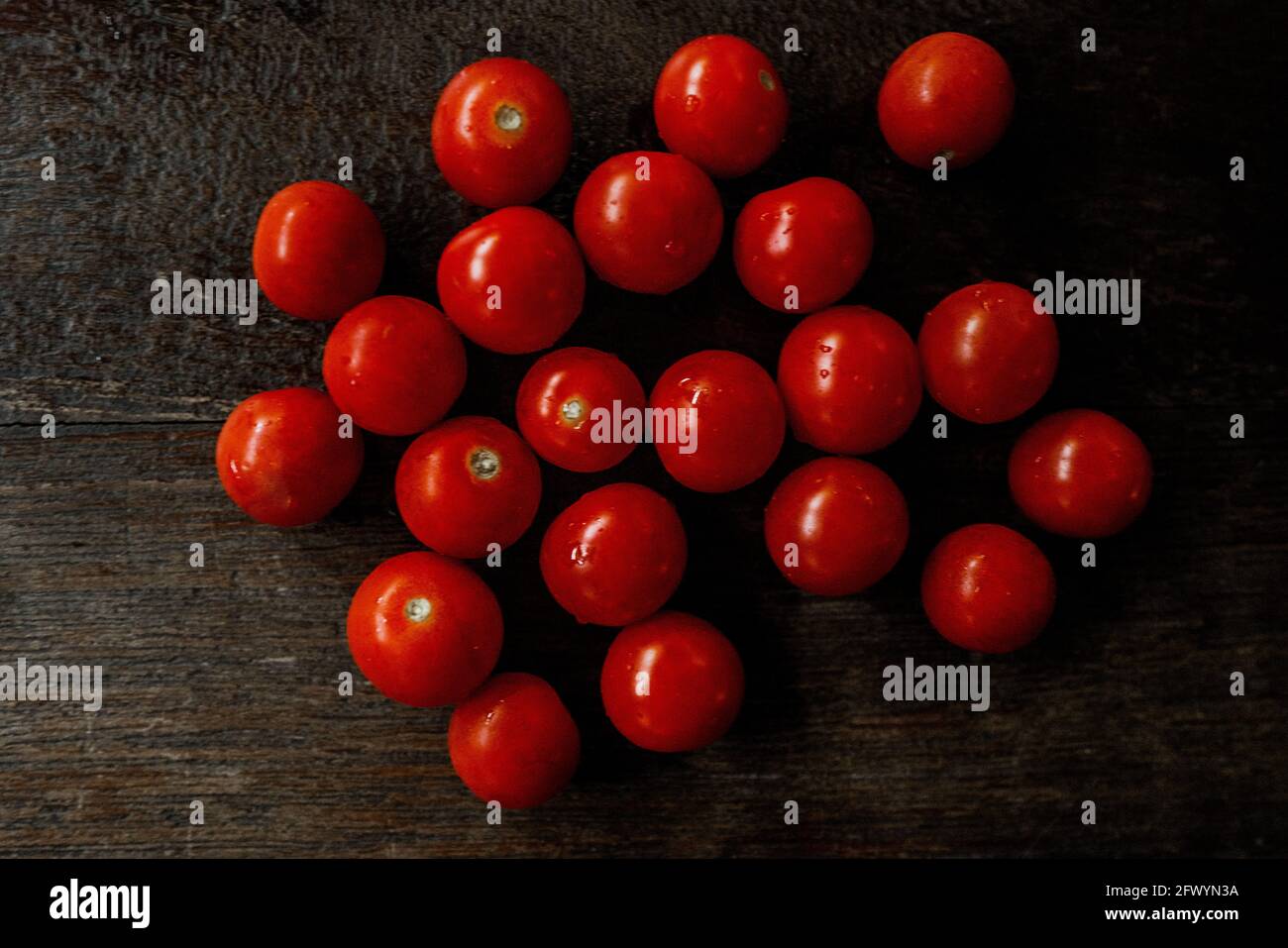 pomodori da cocktail rotondi e lucidi su superficie in legno Foto Stock