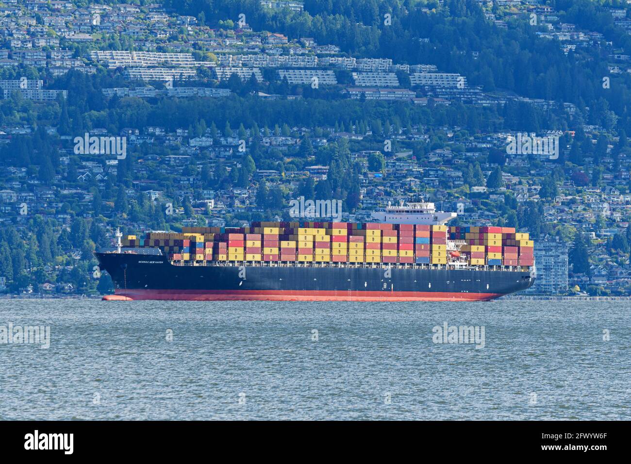 Vancouver, British Columbia, Canada. 18 maggio 2021. La nave portamcontainer 'Seamax New Haven' all'ancora a Burrard Inlet, il porto esterno per il porto di Vancouver, Canada. Sullo sfondo: Alcuni dei costosi immobili di Vancouver Ovest. Credit: Bayne Stanley/ZUMA Wire/Alamy Live News Foto Stock