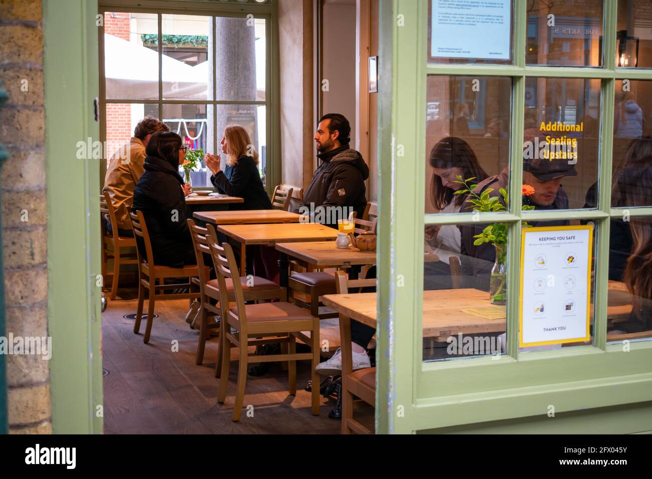 Londra. REGNO UNITO- 05.23.2021. I visitatori e i turisti che cenano in un ristorante nella South Hall del mercato di Covent Garden. Foto Stock