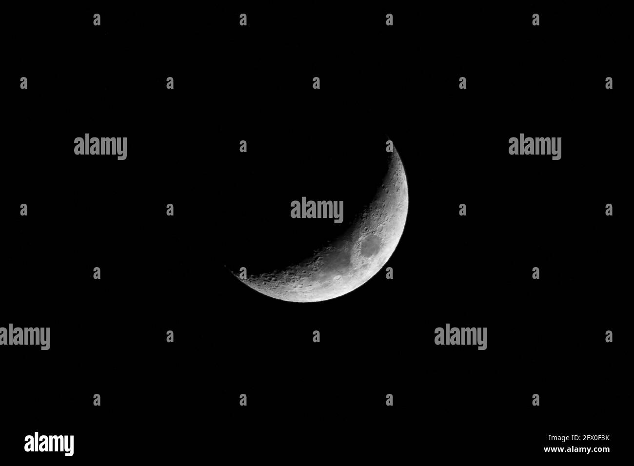 Terra satellite luna a mezzaluna con crateri illuminati su nero scuro cielo di notte Foto Stock