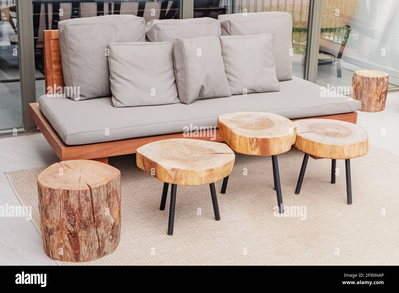 Divano in legno e tavolini da caffè su un'elegante e moderna terrazza Foto Stock