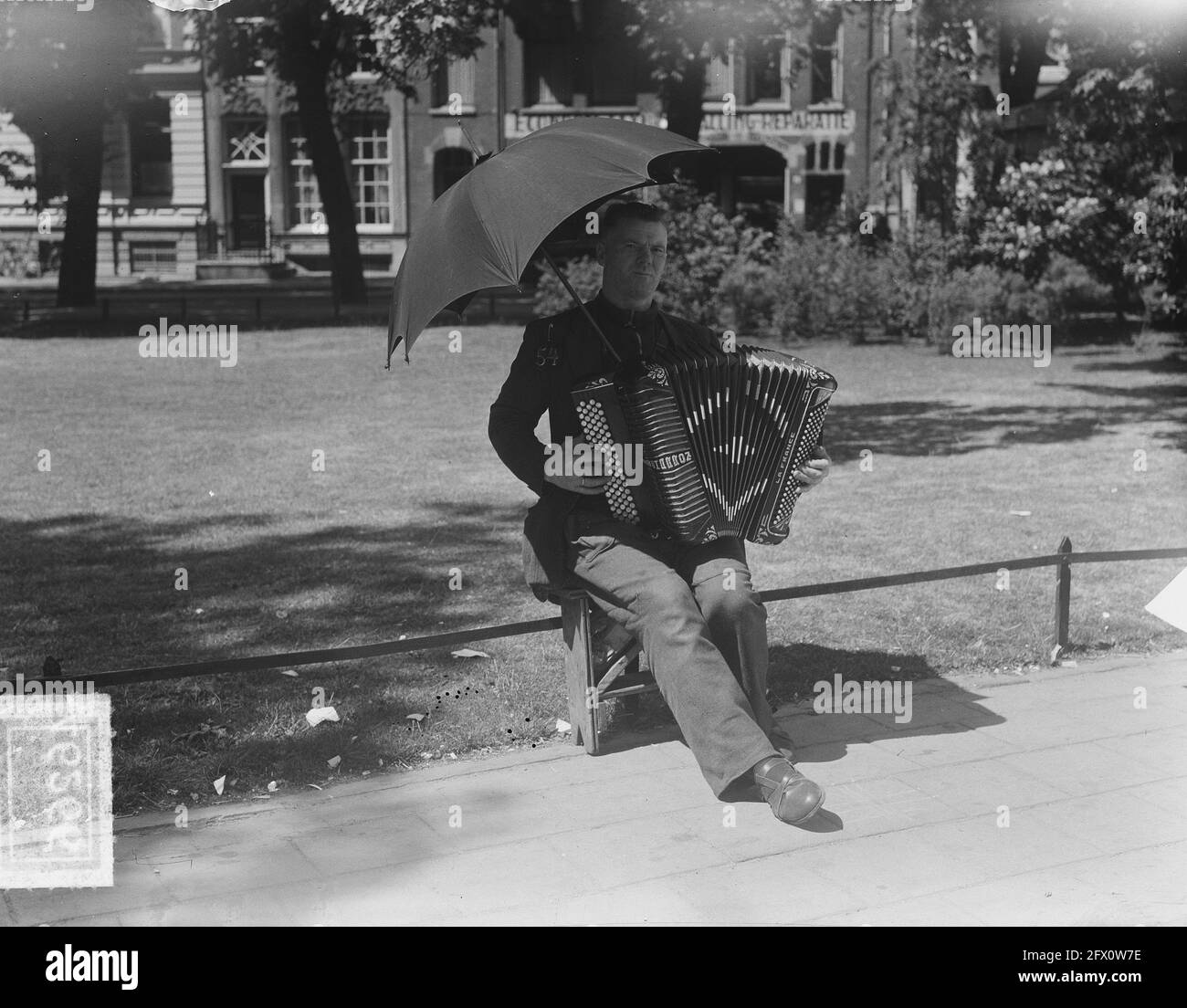 Musicista estivo con ombrello al sole, 20 giugno 1951, ESTATE, SOLE,  Musicisti, ombrelli, Paesi Bassi, foto agenzia stampa del XX secolo,  notizie da ricordare, documentario, fotografia storica 1945-1990, storie  visive, Storia umana