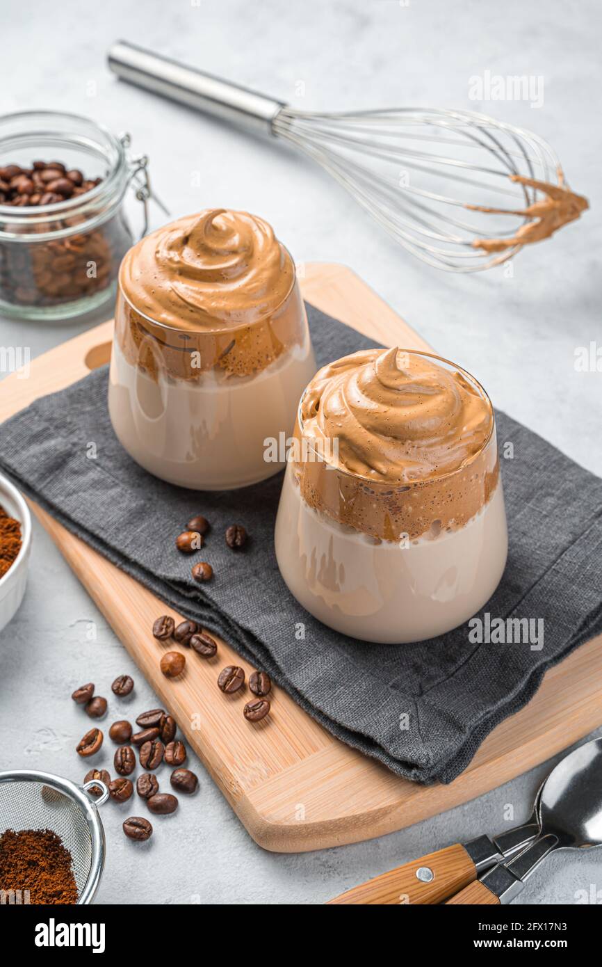 Caffè e chicchi di caffè Dalgona su sfondo grigio. Foto Stock